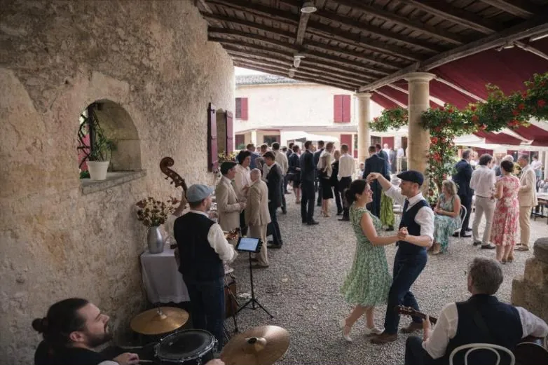 Des invités dansent devant les musiciens, sous une galerie en pierre