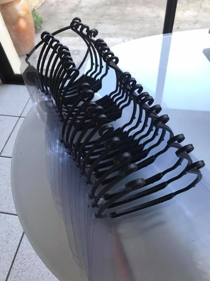Une pile de visières imprimées en 3D, montures noires et écrans transparents